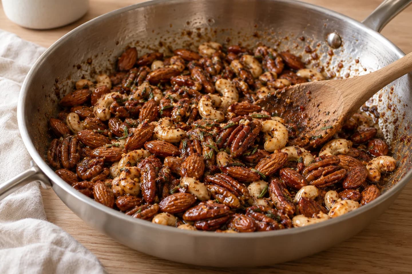 Maple Rosemary Warm Spiced Nuts: Reduce heat to low, stir in maple syrup, rosemary, Aleppo pepper, smoked salt, cinnamon, and cayenne
