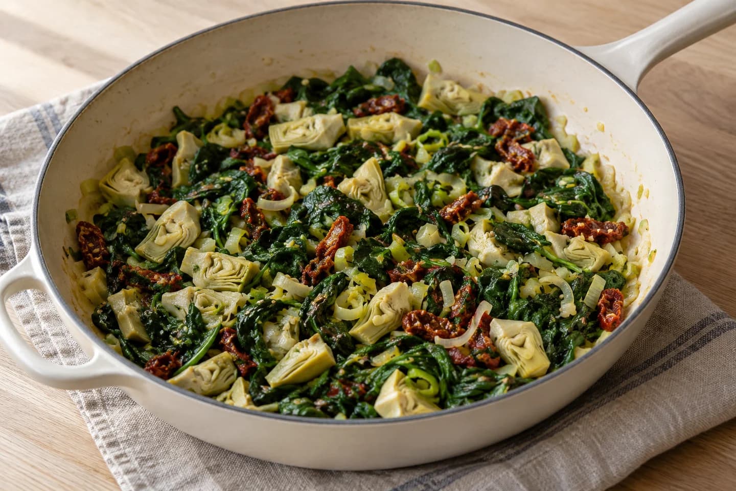 Spinach Artichoke Holiday Strata: Sauté leek in butter until tender, add garlic, spinach, artichokes, and sun-dried tomatoes; cook until spinach wilts